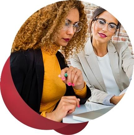 two female executives work together on a laptop